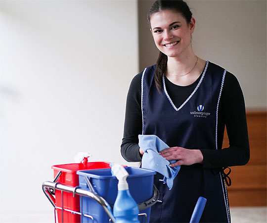 Eine Mitarbeiterin der Vollmergruppe Cleaning bei der Reinigung von Büroräumen.