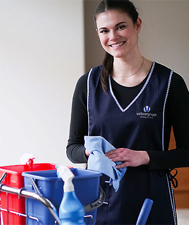 Eine Mitarbeiterin der Vollmergruppe Cleaning bei der Reinigung von Büroräumen.